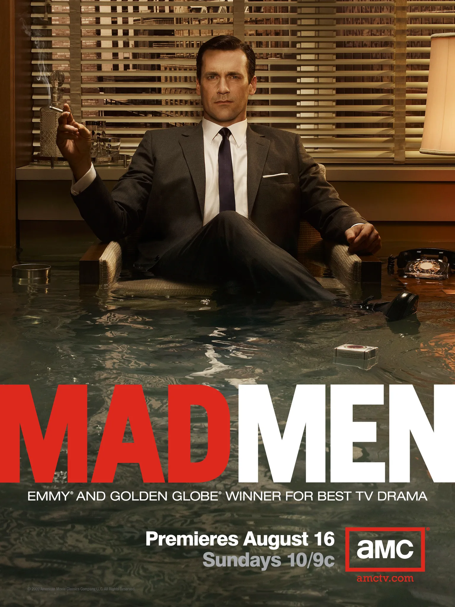 Don Draper karakteriyle Jon Hamm, su basmış ofiste koltukta otururken elinde sigara tutuyor.