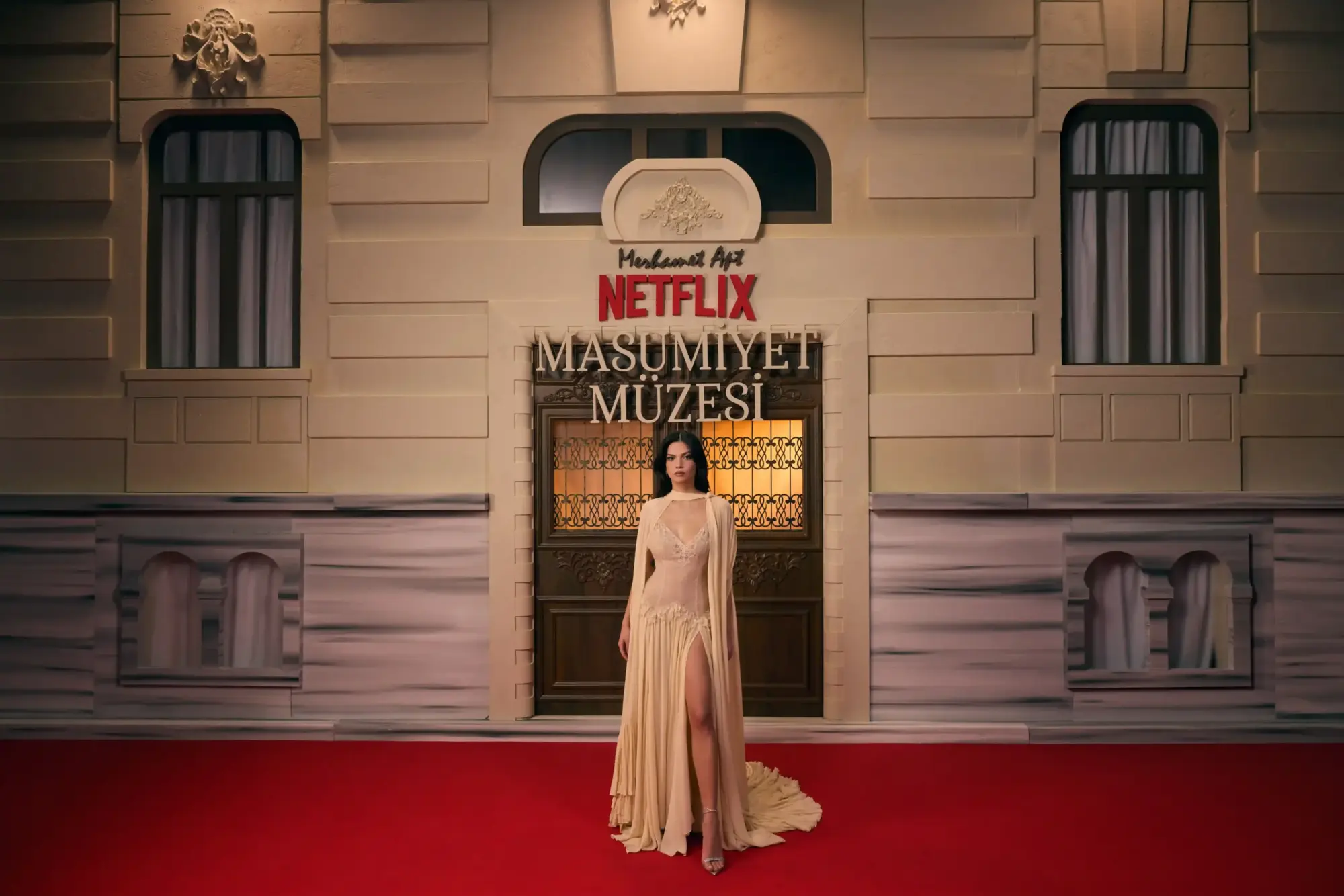 Netflix “Masumiyet Müzesi” galasında kırmızı halıda poz veren Eylül Lize Kandemir; arkada dizi logosu ve tarihi bina cephesi.