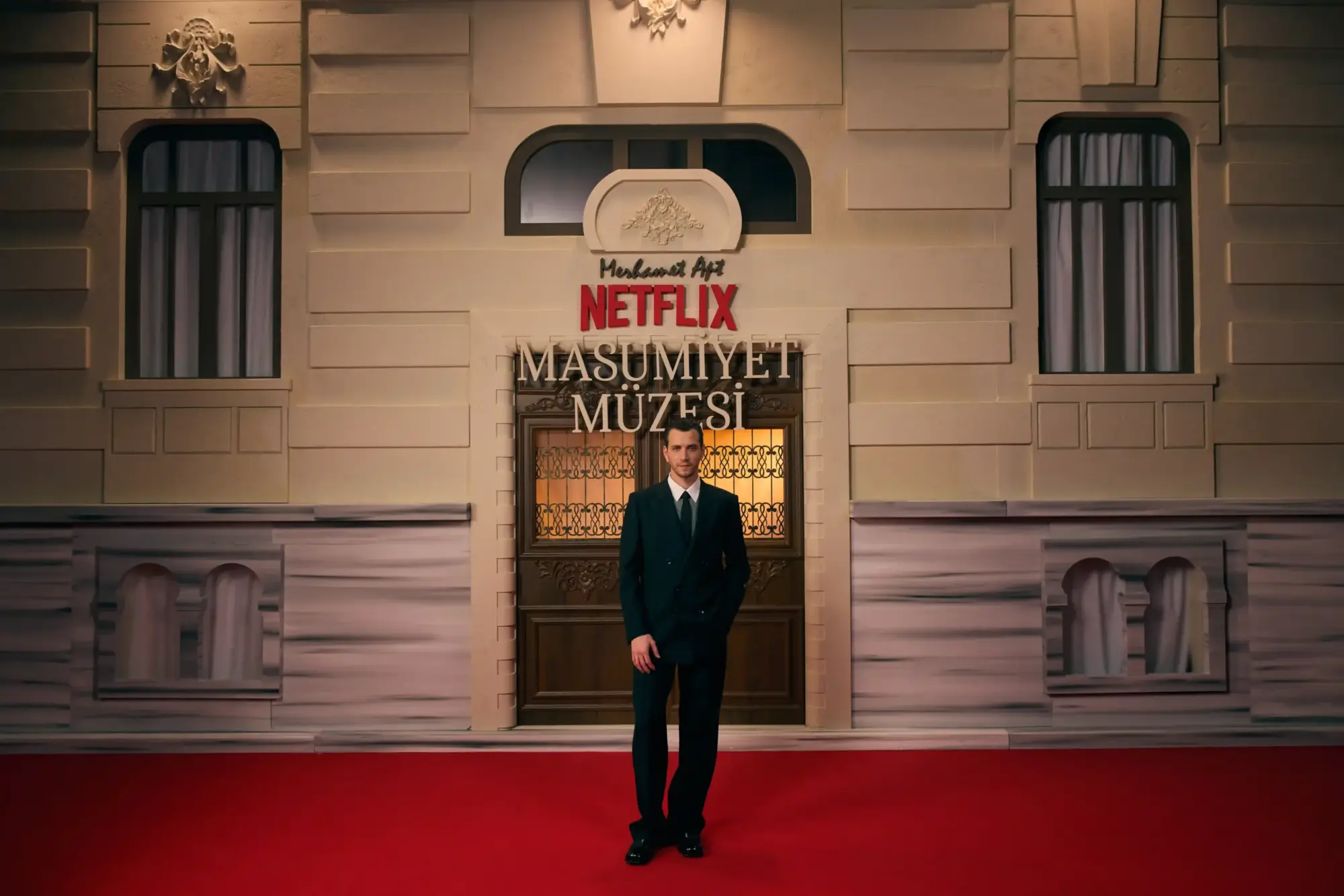 Netflix “Masumiyet Müzesi” galasında kırmızı halıda poz veren Selahattin Paşalı; arkada dizi logosu ve tarihi bina cephesi.