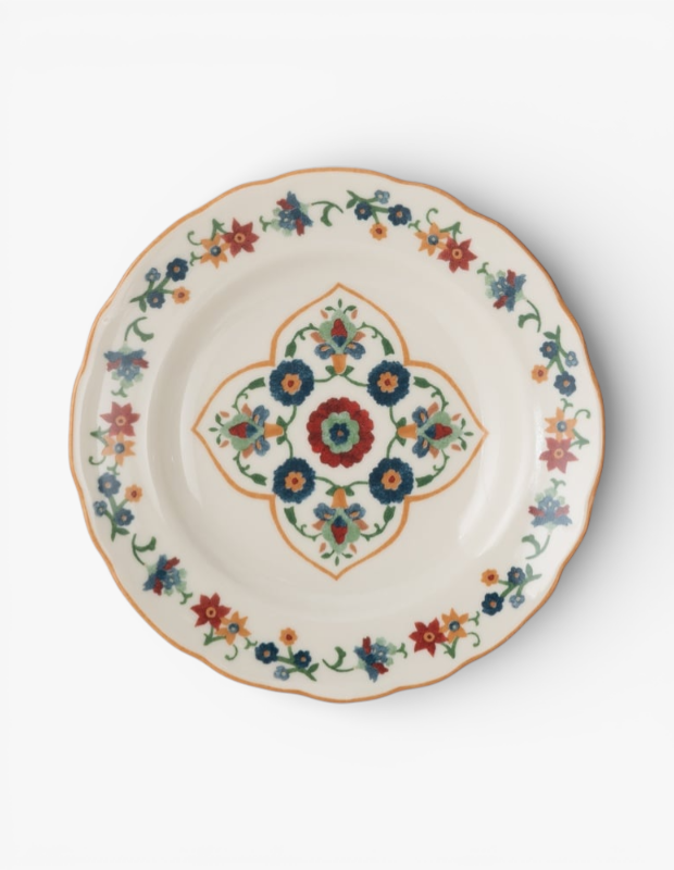 Marka Adı: Mudo
Ürün Cinsiyeti: Belirtilmemiş
Ürün Tipi: Tatlı Tabağı
Ürün Sezonsallığı: Bahar/Yaz
Ürün Çeşidi: Porselen/Seramik Tatlı Tabağı
Ürün Özellikleri: Krem/bej tonlarındaki yuvarlak zemine sahip, kenarları dalgalı formda tasarlanmış bu tatlı tabağı, canlı renklerdeki stilize çiçek ve yaprak motifleriyle bezenmiştir. Tabağın orta kısmında simetrik ve detaylı bir çiçek deseni yer alırken, kenar çevresi boyunca yine çiçek motiflerinden oluşan zarif bir bordür ve ince turuncu bir çerçeve bulunmaktadır. Geleneksel el sanatlarından ilham alan eklektik stili, modern ve hikayesi olan sofralar için özgün bir dokunuş sunar.
Öne Çıkan Detaylar:
- Çok renkli, stilize çiçek ve yaprak motifleriyle bezeli, canlı desen.
- Dalgalı (fırfırlı) kenar hattı ve turuncu renkli ince çerçeve detayı.
- Sofralara sıcaklık ve karakter katan, krem/bej tonlarında zarif zemin rengi.
Kimler Kullanıyor?: Sofralarında kişisel bir hikaye anlatmayı seven, geleneksel motifleri modern yorumlarla birleştirmekten hoşlanan, misafir ağırlamayı ve yemek deneyimini bir sanata dönüştüren kişiler için idealdir. Ev dekorasyonunda canlı renkleri ve özgün desenleri tercih eden, eklektik bir tarzı benimseyenler, bu tabağın sofralarına katacağı sıcak ve neşeli havayı takdir edeceklerdir. Monotonluktan uzak, karakterli ve samimi ortamlar yaratmaktan keyif alan herkesin beğenisini kazanır.