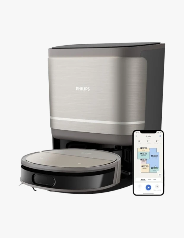 Beyaz bir stüdyo zemininde duran, bej ve koyu gri renklerdeki Philips marka otomatik boşaltma istasyonuna yanaşmış robot süpürge ile yanında şarj seviyesi, ev haritası ve temizlik modlarını gösteren bir akıllı telefon uygulaması sergileniyor.