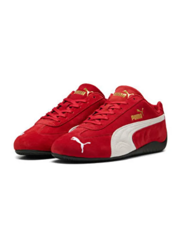 İki adet kırmızı süet Puma Speedcat OG unisex sneaker, yanlarda ikonik beyaz Formstrip şeridi, dillerinde altın renkli Puma yazısı ve burun kısmında beyaz atlayan kedi logosuyla, zamansız tasarımı ve modern çizgileri birleştiren klasik bir görünüm sergiliyor.