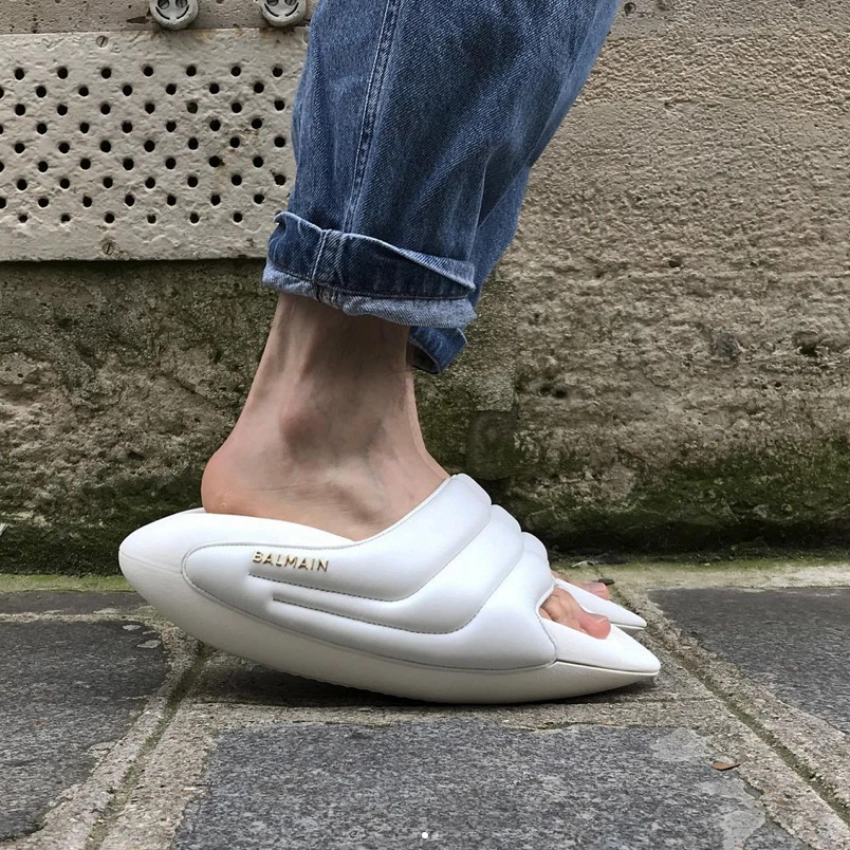Kot pantolonla kombinlenmiş beyaz Balmain terlik modeli, sokakta çekilmiş günlük stil detay fotoğrafı.