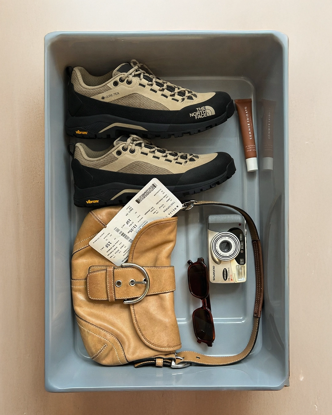 GORE-TEX teknolojili outdoor ayakkabı modeli, dayanıklı taban yapısı ve suya dayanıklı üst yüzeyiyle seyahat sırasında konfor ve koruma sunarken; deri omuz çantası, güneş gözlüğü ve kompakt kamera gibi aksesuarlarla birlikte fonksiyonel ve stil sahibi bir travel gear seçkisi oluşturuyor.