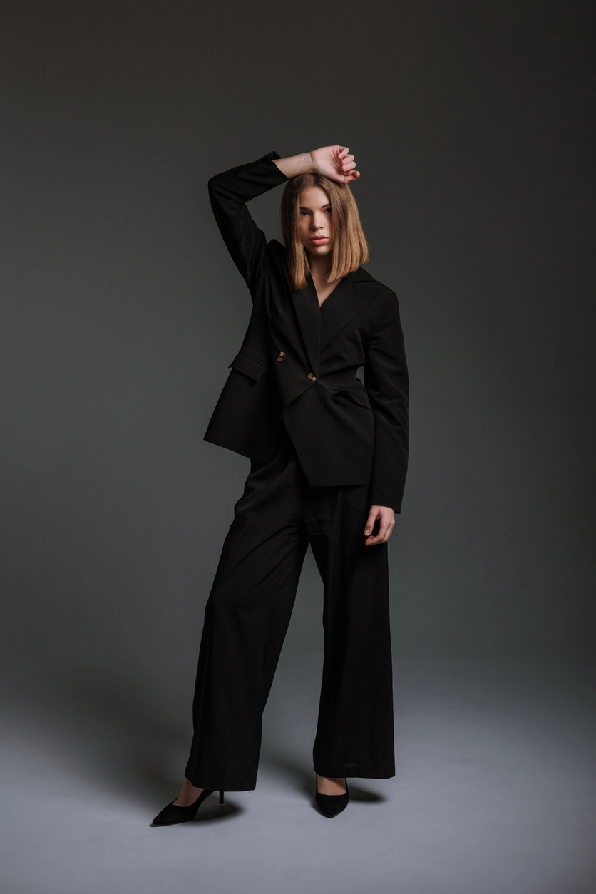 Wide leg pantolon ve yapılandırılmış siyah blazer kombinasyonu ile modern tailoring estetiğini yansıtan zamansız, güçlü ve sofistike siluet.