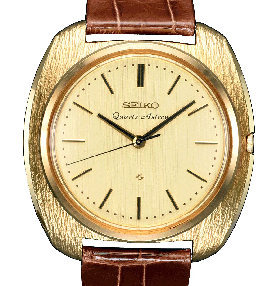 1969 yılına ait ilk Quartz-Astron saatlerinden biri olan bu Seiko modeli, dokulu altın rengi kasası, altın renkli kadranında belirgin SEIKO Quartz-Astron yazısı ve kahverengi timsah derisi desenli kayışıyla zarif bir kol saati olarak tüm detaylarıyla önden görülüyor.