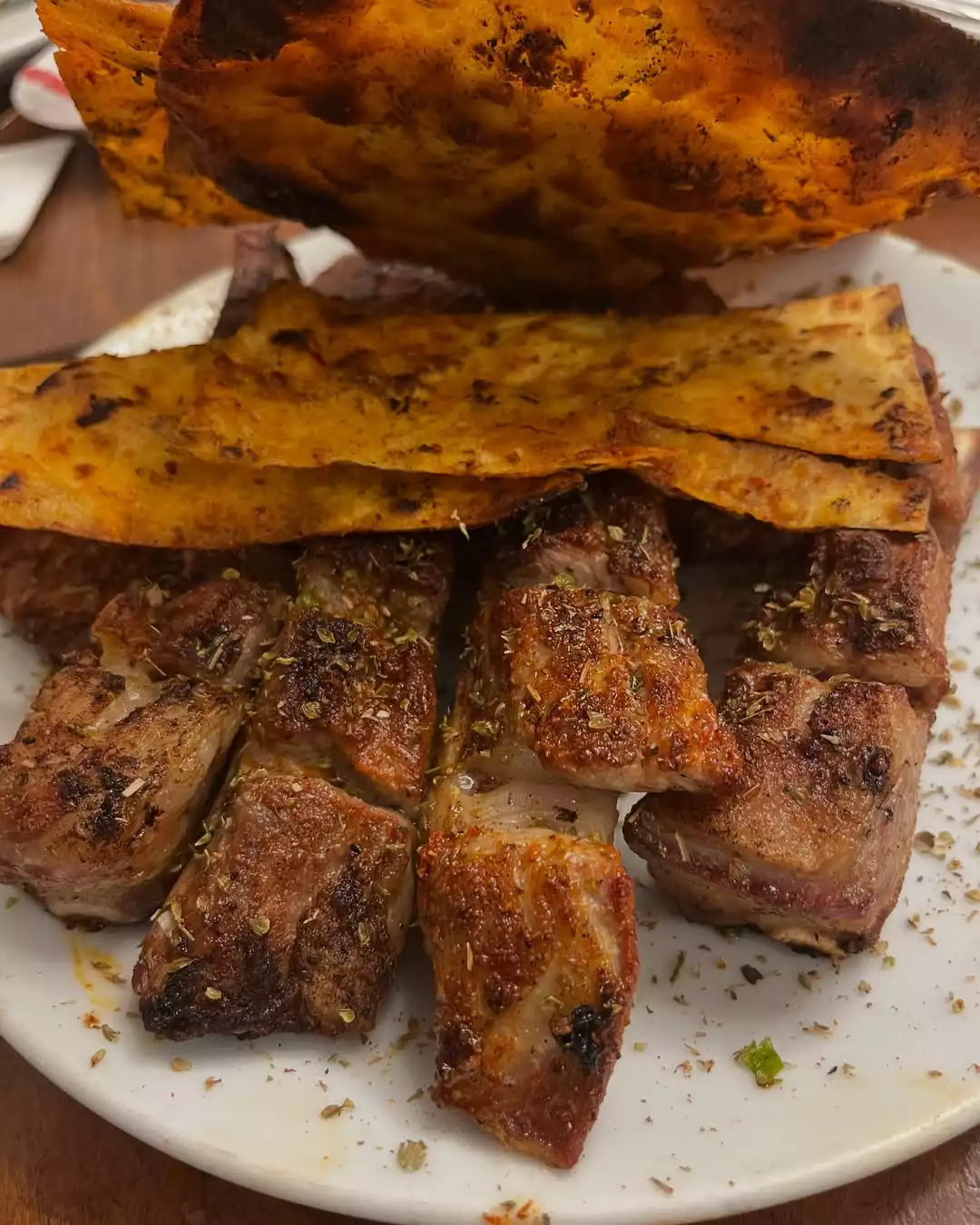Şefin favori lezzet kaçamağı Adana Ocakbaşı Kurtuluş'ta sunulan tabak; üzerinde kekik serpilmiş nar gibi kızarmış iri et ve uykuluk parçaları ile onları iştah açıcı biçimde örten baharatlı çıtır lavaşıyla otantik bir kebap deneyimi