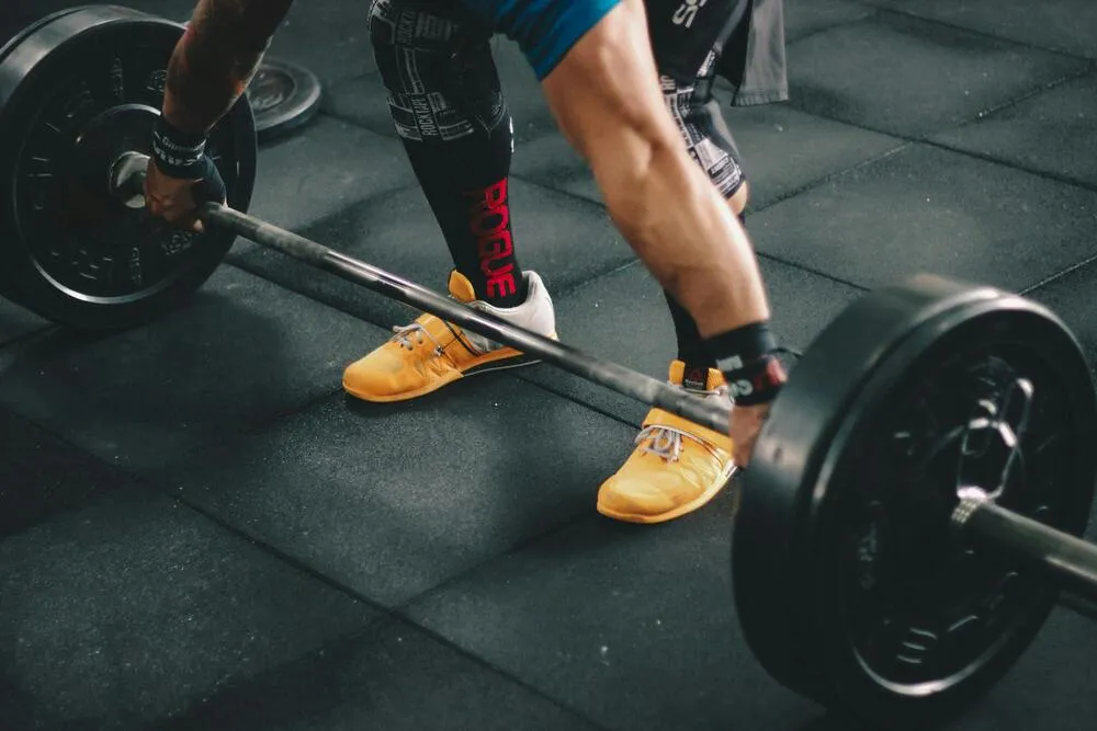 Deadlift hareketi yapan sporcu ve barbell detayı