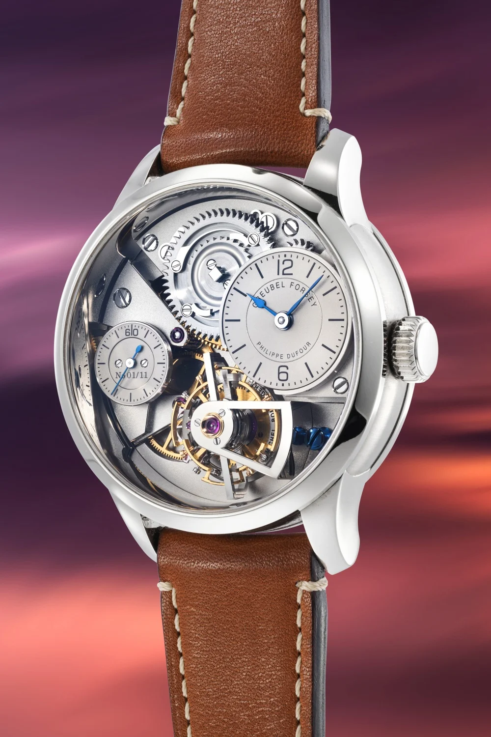 Gümüş renkli kasası, kahverengi deri kayışı, Greubel Forsey ve Philippe Dufour imzalı şeffaf kadranı, karmaşık dişli mekanizması, altın rengi tourbillonu ve N 01/11 seri numarasıyla saat yapımcılığının zanaatkarlığını gözler önüne seren lüks bir mekanik kol saati.