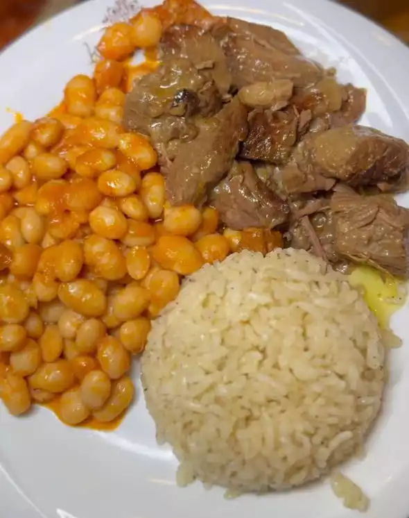 Favori esnaf mekanı Kaçkar Lokantası'nı temsil eden klasik üçlü. Beyaz tabakta özenle sunulan tane tane pirinç pilavı, salçalı sosuyla iştah açan kuru fasulye ve kendi yağında parlayan kavurma yan yana sunuluyor.