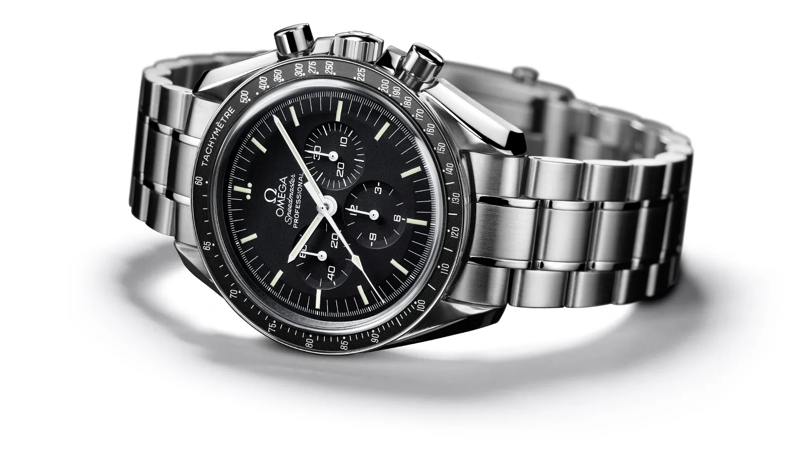 Beyaz bir arka plan üzerinde, ikonik OMEGA Speedmaster Professional modelinin ışıltılı metal kasası ve siyah kadranı öne çıkarılırken, kronograf alt kadranları ve takimetre bezeli, 1968 yılındaki modelin zarafetini ve işlevselliğini vurgulayan detayları gözler önüne seriyor.