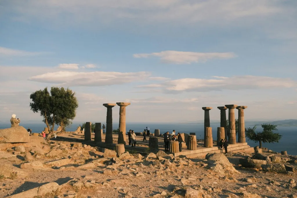 Gün batımına yakın saatlerde, Ege Denizi’ne hakim tepede yer alan Assos Antik Kenti’ndeki Athena Tapınağı’nın Dor sütunları arasında dolaşan ziyaretçiler, Çanakkale’nin tarihi dokusunu ve nefes kesen manzarasını deneyimliyor.