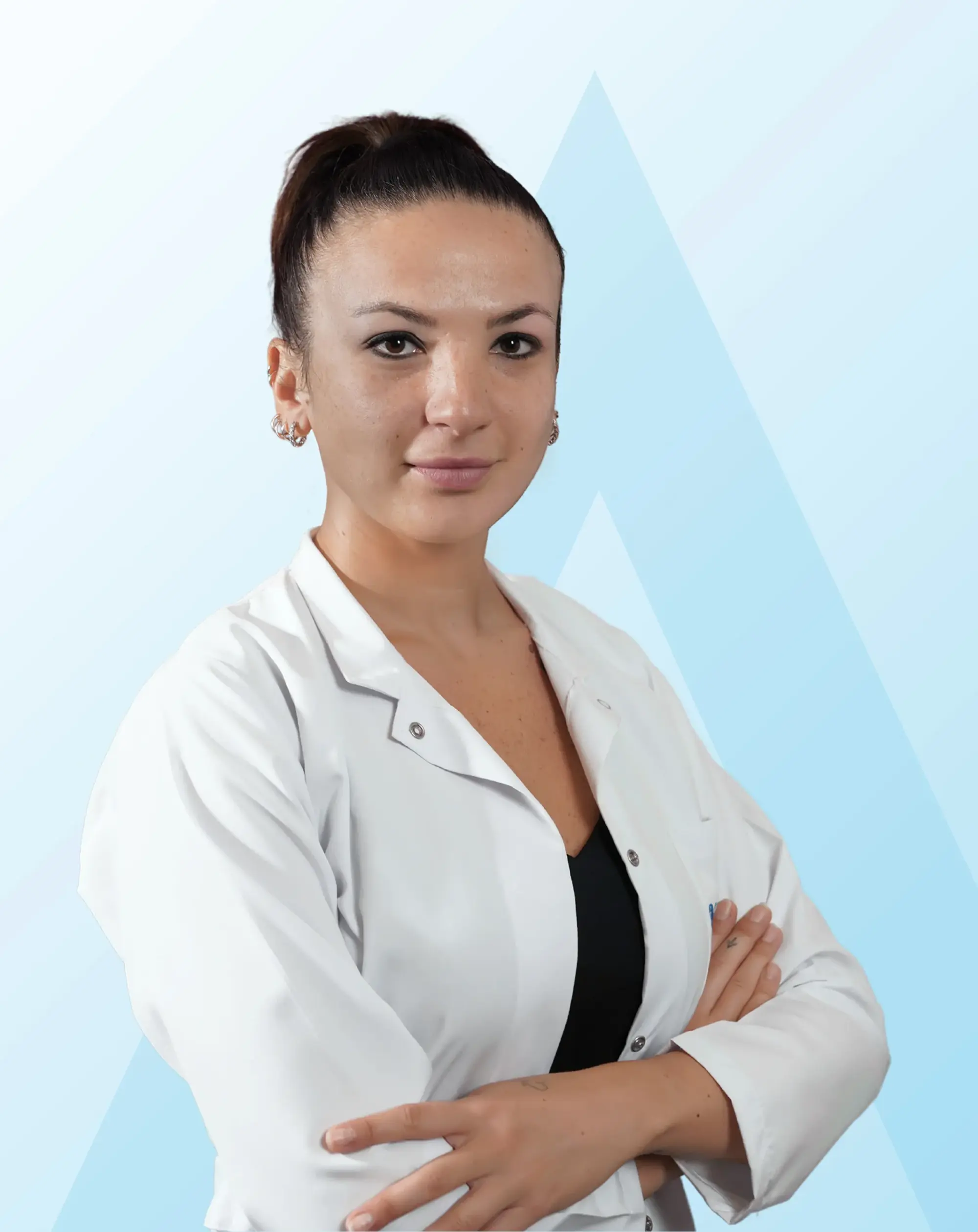 Beyaz önlüklü Doktor Sena Sivri, kollarını kavuşturmuş ve hafifçe gülümseyerek doğrudan kameraya bakarken, mevsimsel duygu durum bozukluğu ile mücadelede aromaterapinin biyokimyasal dengeyi sağlamadaki rolünü anlatan yazıda okuyuculara rehberlik ediyor.
