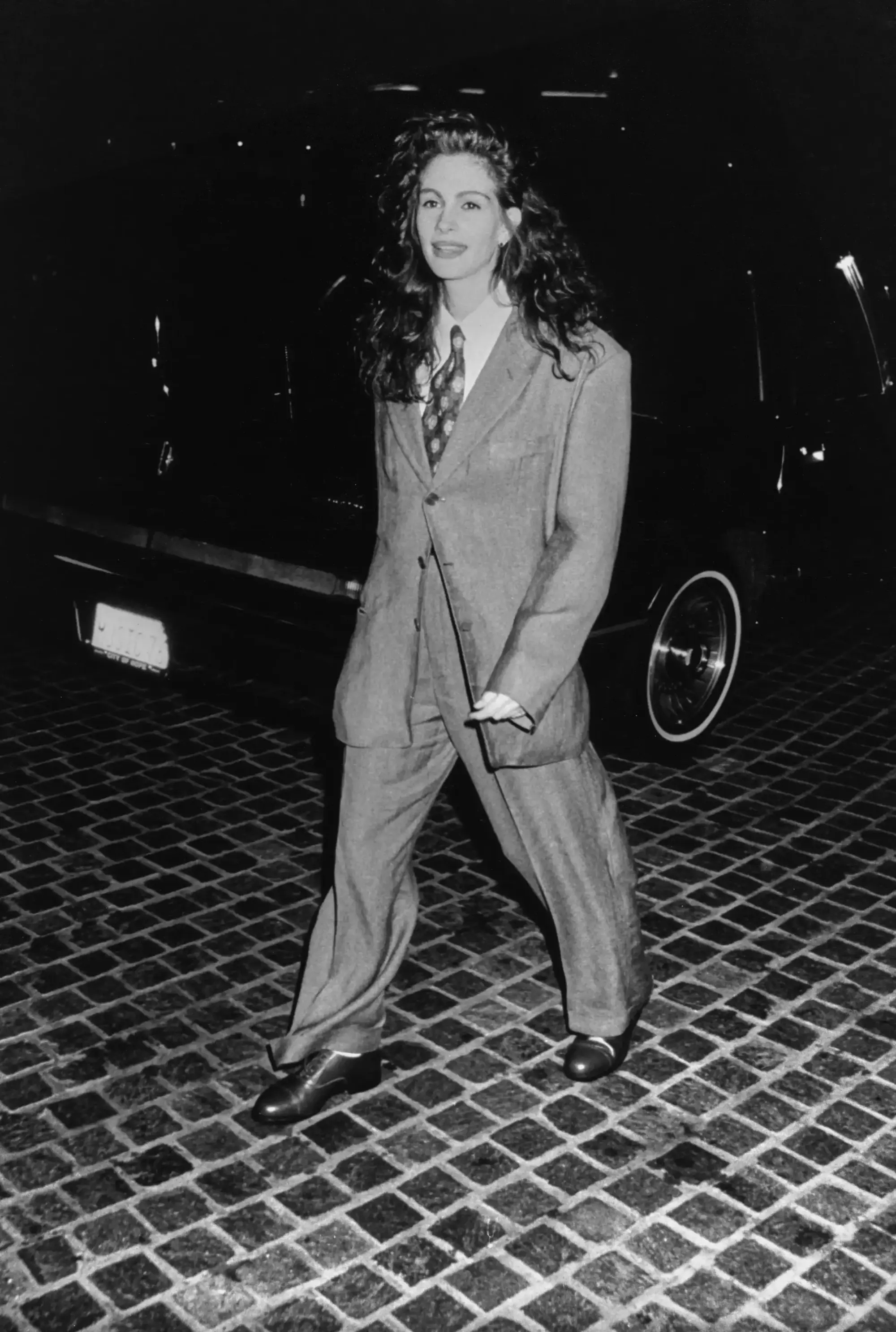 Julia Roberts, 1990 Altın Küre Ödülleri’nde maskülen terziliği güçlü bir özgüvenle yorumlayarak kırmızı halı stiline farklı bir yaklaşım getiriyor. Oversize kesimli takım elbisesi, gömlek ve kravatla tamamlanan görünümü; dönemin klasik kadın kırmızı halı kalıplarının dışına çıkan cesur ve ikonik bir stil anı olarak hatırlanıyor.