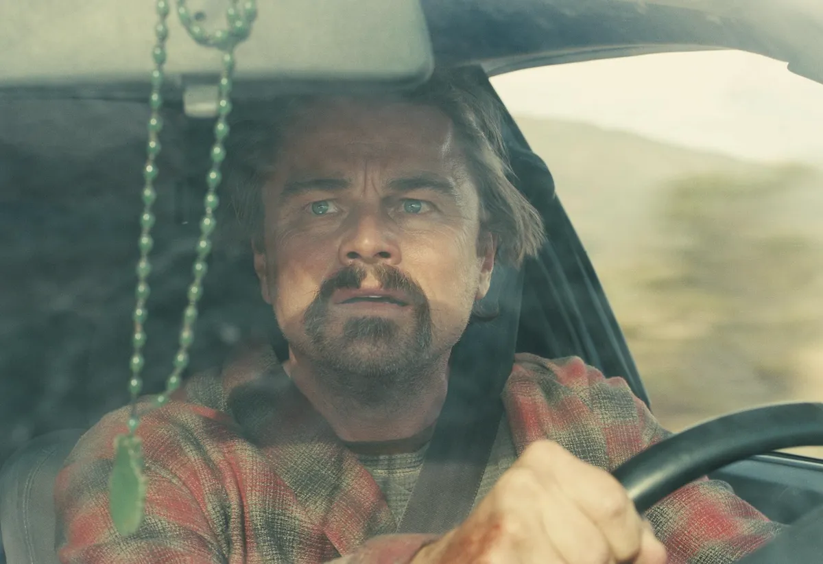 Leonardo DiCaprio, kirli sakallı, dalgalı saçlı ve kırmızı ekoseli gömleğiyle bir arabanın direksiyonunda, endişeli mavi gözleriyle ileriye bakarken görülüyor; ön camdan sarkan yeşil tespih ve elindeki yara izi, zorlu bir yolculukta karşılaştığı birbiri ardına gelen mücadeleleri düşündürüyor.