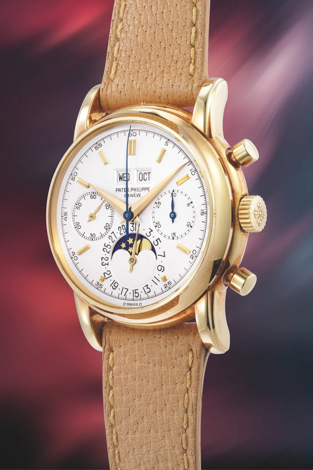 Yüksek açıyla çekilmiş bu detaylı karede, altın kasalı ve bej rengi dokulu deri kayışa sahip Patek Philippe Perpetual Calendar Chronograph kol saati, beyaz kadranında gün, ay, saniye ve 30 dakika kronograf alt kadranları ile lacivert zeminli ay fazı göstergesini barındırarak göz kamaştırıyor.