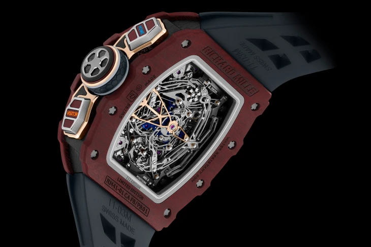 Richard Mille RM 41-01 lüks kol saatinin koyu bordo renkli titanyum kasalı, şeffaf arka kapağından tüm detaylarıyla görünen karmaşık mekanizması; mor mücevherleri, altın rengi köprüleri ve saatin yan tarafındaki yenilikçi ayar düğmeleriyle dikkat çekiyor.