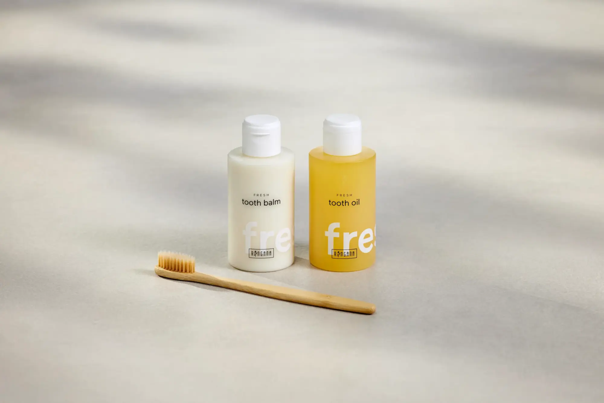 Nisan ayındaki marka yeniliklerini öne çıkaran bir görselde, Ringana'nın doğal ağız bakımı serisinden, üzerinde FRESH tooth balm yazan opak beyaz bir şişe ile FRESH tooth oil yazan şeffaf sarı bir şişe, yanlarında ahşap bir diş fırçasıyla aydınlık bir yüzeyde, yumuşak gölgeler eşliğinde dikkat çekiyor.