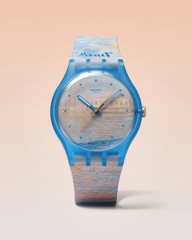 Şeffaf mavi kasaya ve kordona sahip bu Swatch saati, kadranında ve kordonunda ünlü Claude Monet'nin tarzında, su kenarındaki binaları betimleyen izlenimci bir manzara resmini taşırken, üst kordonunda Monet imzası ve saati gösteren mavi ve turuncu akrep-yelkovan ile dikkat çekiyor.