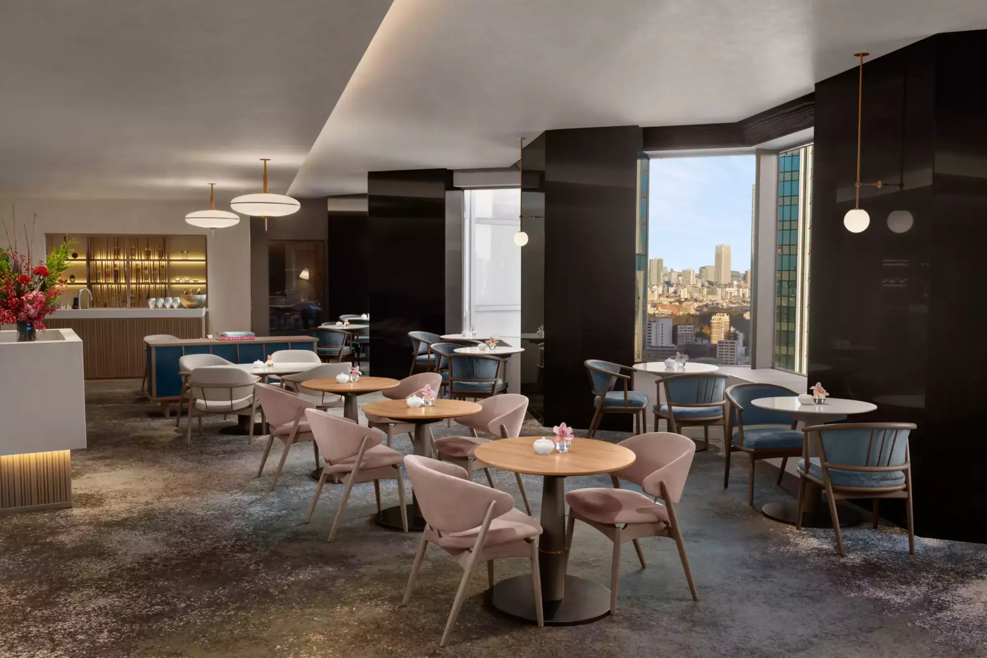 36. katta bulunan yeni Club InterContinental Lounge'da, pembe ve mavi tonlarda rahat sandalyelerin eşlik ettiği yuvarlak masalar, arkada şık bir bar alanı ve geniş pencerelerden eşsiz şehir manzarası sunan modern ve davetkar bir atmosfer.