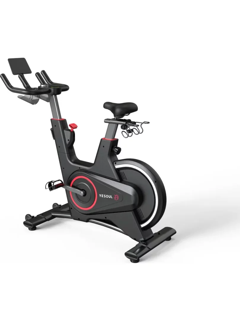 Siyah renkte, modern tasarımlı, önünde ekran tutucusu ve ayarlanabilir gidon ile sele bölümleri bulunan, YESOUL markasına ait bu akıllı fitness bisikleti, volan kapağındaki kırmızı detaylar ve selenin arkasındaki aksesuar askılığı ile evde spor deneyimi için kullanışlı bir fitness aracı olarak öne çıkıyor.