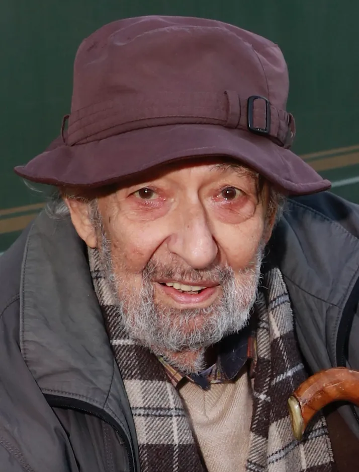 Usta fotoğrafçı Ara Güler, kendine özgü koyu renkli şapkası, gür beyaz sakalı ve ekose atkısıyla samimi bir gülümsemeyle objektife bakarken, alt sağda bastonunun ucu görülen bu portresinde ‘Ara Güler kimdir’ sorusuna bir cevap niteliği taşıyor.