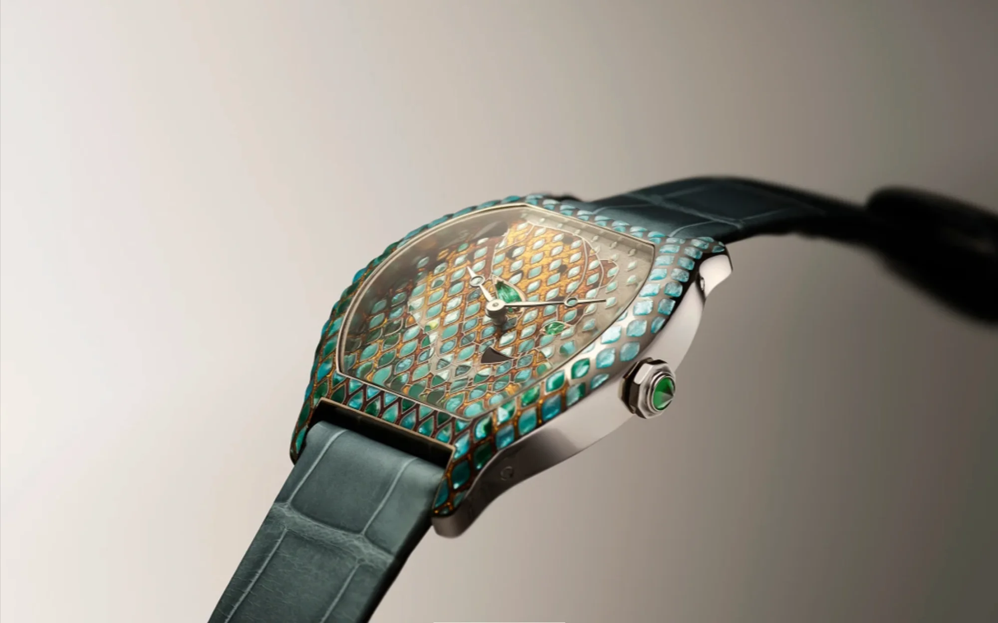Watches and Wonders etkinliğinde tanıtılan Cartier Tortue Panther serisinden, turkuaz ve altın rengi pullarla bezeli kadranı ve kasa çerçevesiyle göz alıcı, yeşil cabochon kurma kolu ve ton sür ton deri kayışa sahip zarif bir kol saati.
