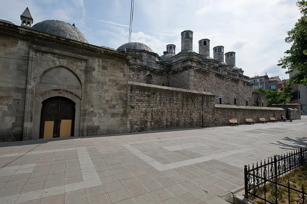 Güneşli bir havada çekilen bu geniş açılı görselde, kesme taş duvarları, ardışık kubbeleri ve karakteristik bacalarıyla Haseki Külliyesi'nin bir kısmı, Mimar Sinan'ın erken dönem Osmanlı mimarisi dehasını yansıtan bir yapıt olarak avludan yükseliyor.
