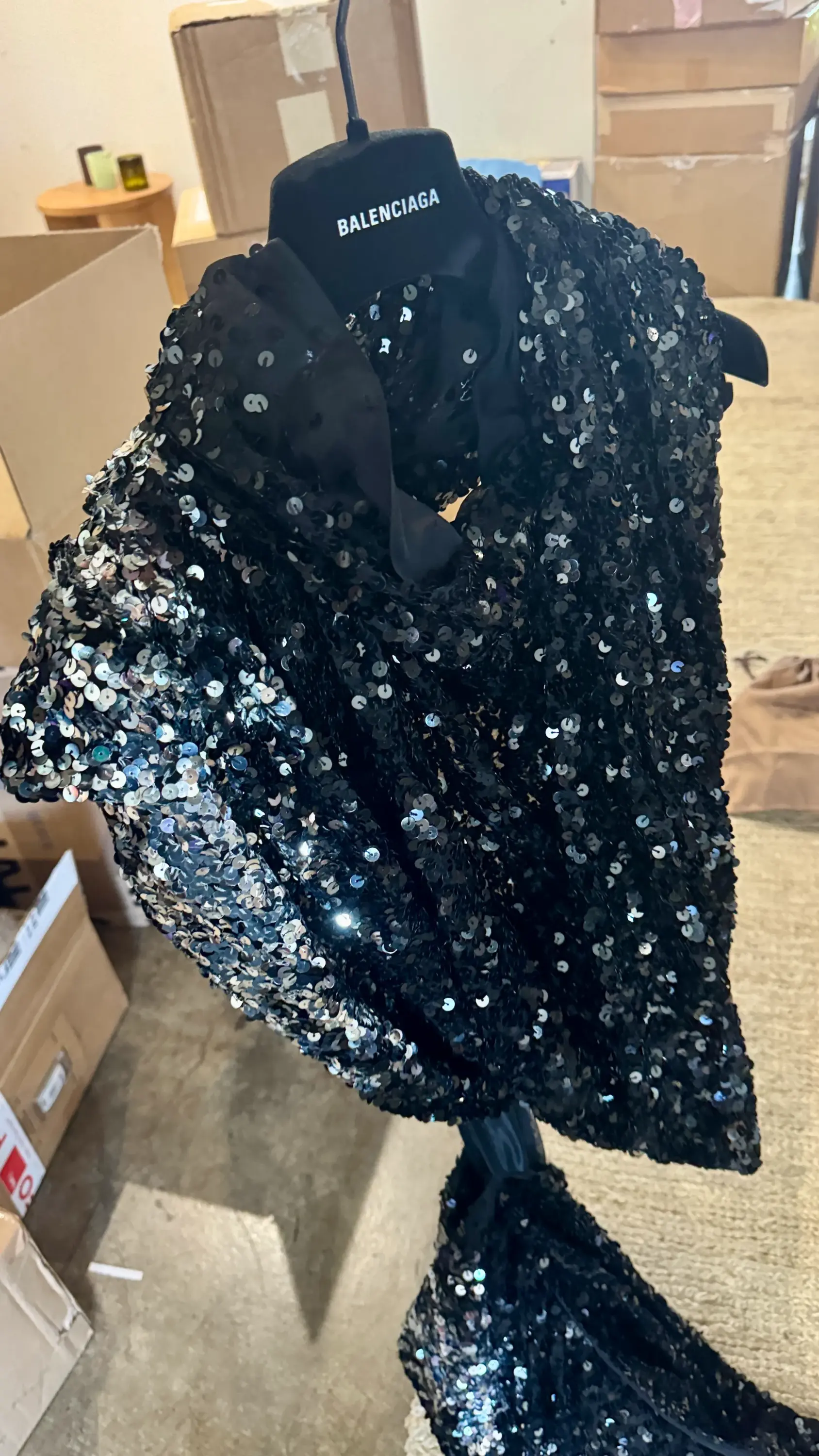Balenciaga askısında asılı, Naomi Watts için İpek Ersoy Gelgin tarafından stilize edilen, Oscar gecesi kırmızı halısı için düşünülen, koyu renk pullarla tamamen işlenmiş bu asimetrik gece elbisesi, ışıkla etkileşerek göz alıcı bir parıltı saçıyor.