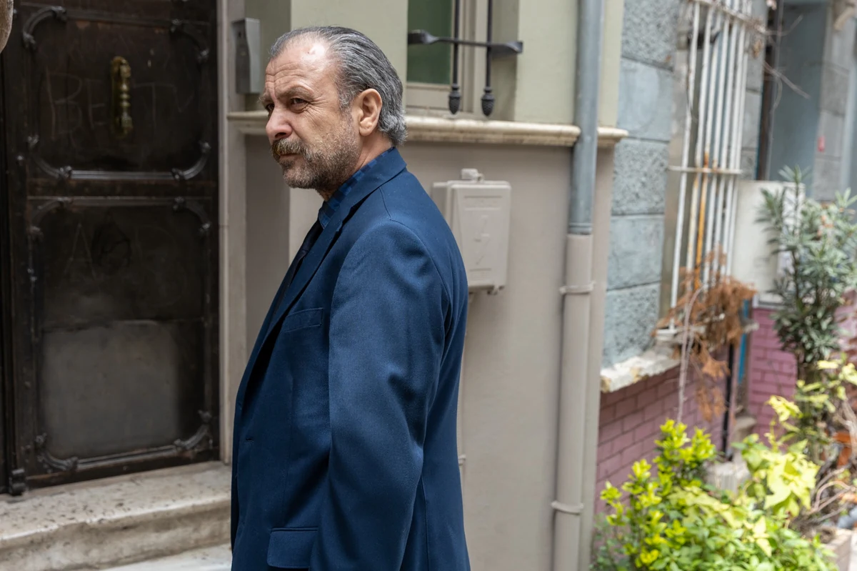 Gri saçları ve bıyıklarıyla, koyu renk takım elbise giymiş oyuncu Nejat İşler, Netflix’in yeni yerli polisiye dizisi İstanbul Hatırası’nda Başkomiser Nevzat rolüyle, eski bir İstanbul sokağında düşünceli bir ifadeyle duruyor.