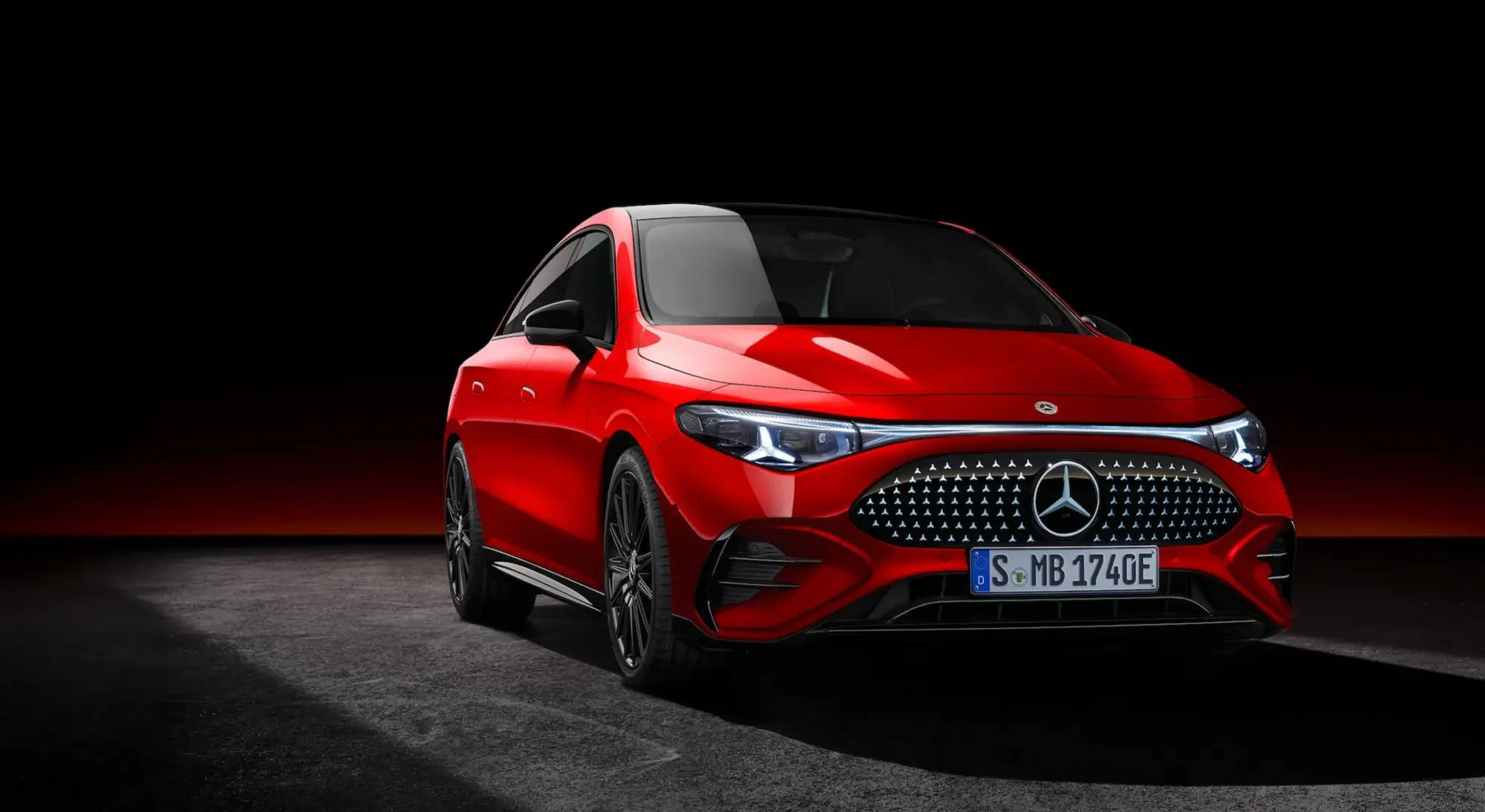 Karanlık bir zeminde parlak kırmızı rengiyle dikkat çeken, modern LED farları ve ön ızgarasındaki yıldız deseniyle göz alıcı bir şıklık sunan yeni nesil Mercedes-Benz CLA elektrikli otomobil, hafif açıyla önden görünüyor.
