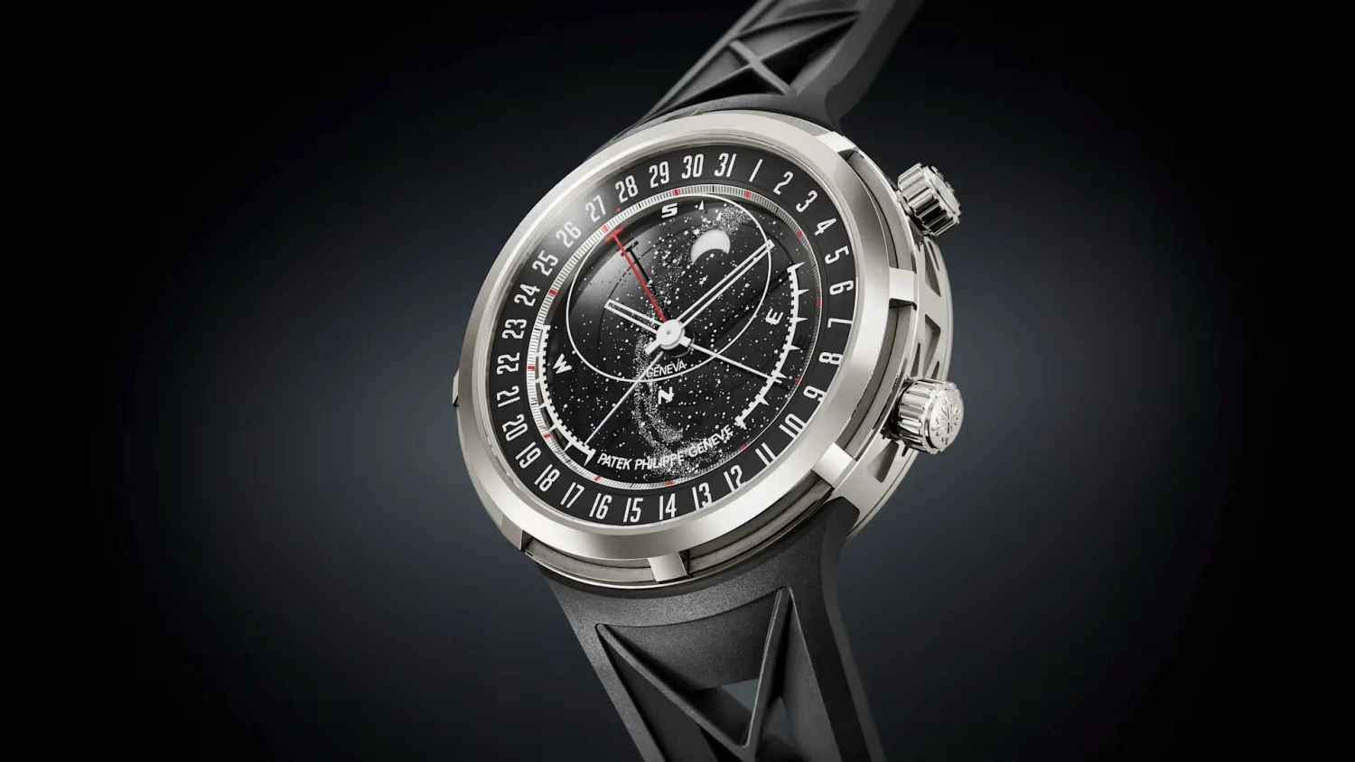 Patek Philippe marka, gümüş renkli kasaya ve belirgin siyah kauçuk kordona sahip lüks bir saatin yakın çekim görüntüsü; kadranında yıldızlı bir gökyüzü, ay evresi göstergesi, tarih halkası ve pusula yer alarak bu Grand Complication modelinin karmaşık işlevselliğini gözler önüne seriyor.