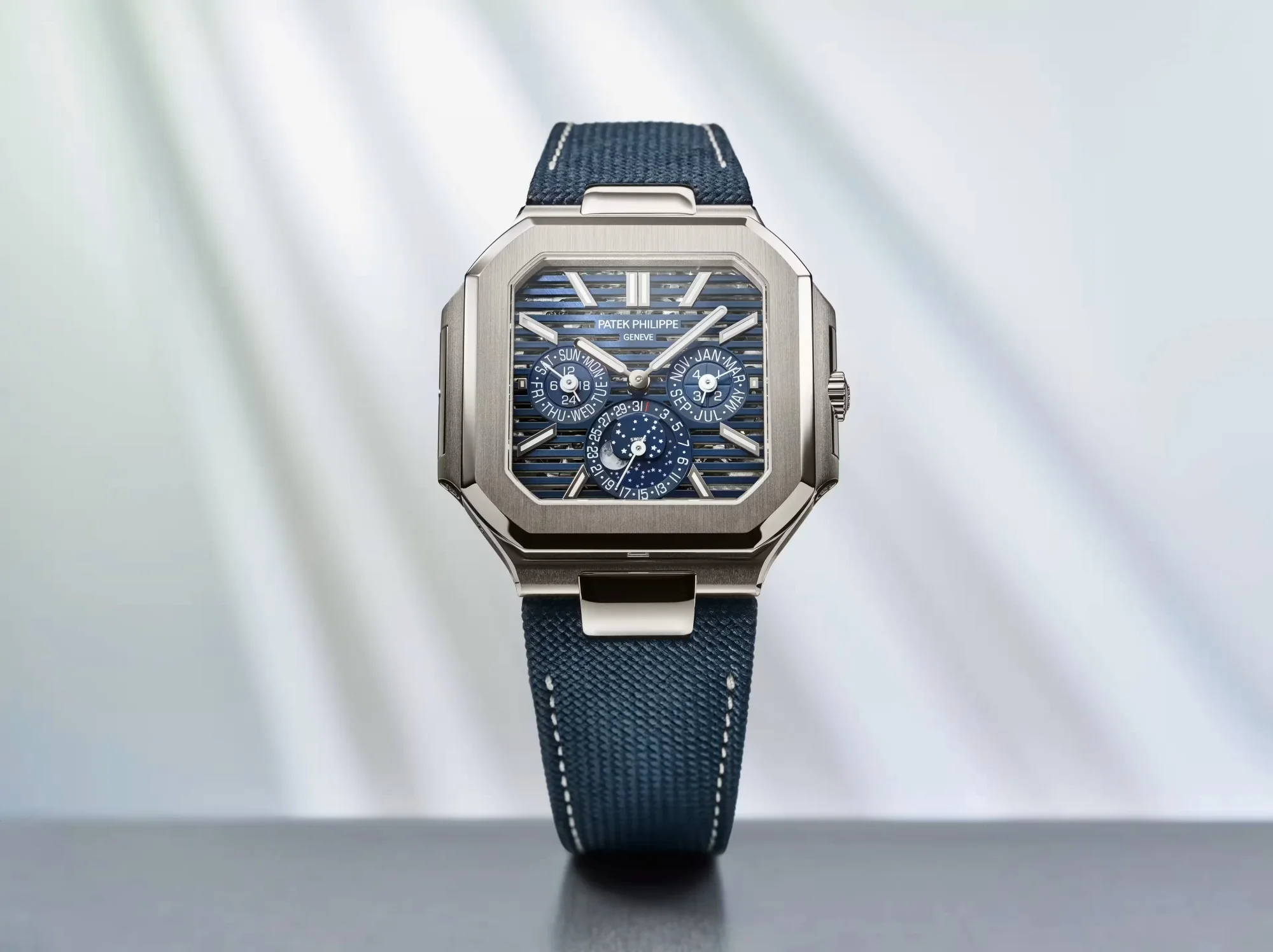 Patek Philippe'nin Watches and Wonders etkinliğinde dikkat çeken, fırçalanmış platin kasalı ve karakteristik sekizgen Cubitus formundaki 5840P Sürekli Takvim kol saati, çizgili mavi kadranı ile lacivert tekstil kayışının uyumuyla zarifçe sunuluyor.