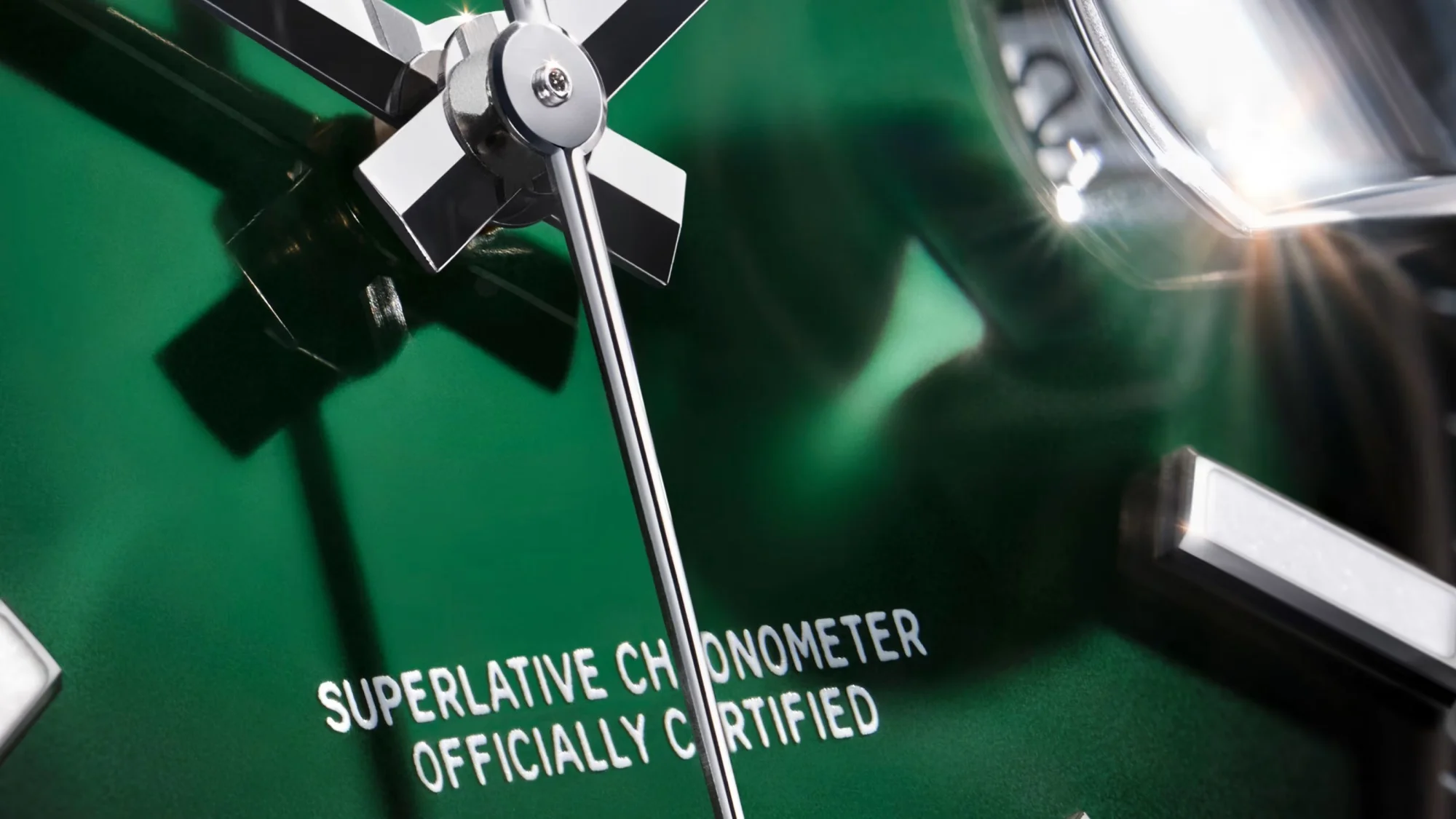 Bu yakın plan çekim, parlak yeşil kadranıyla göz alıcı Rolex Datejust saatinin detaylarını sergiliyor; parıldayan gümüş ibreler, net okunabilen SUPERLATIVE CHRONOMETER OFFICIALLY CERTIFIED yazısı ve kadranın lüks dokusundaki ışık yansımaları belirginleşiyor.
