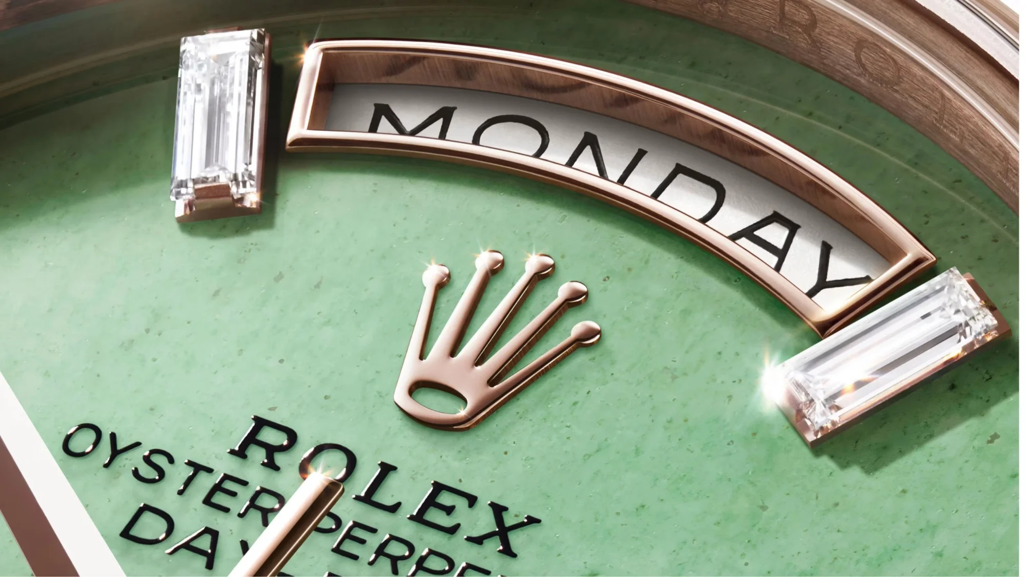 Gösterişli Rolex Day-Date 40 modelinin göz alıcı yeşil aventurin kadranı üzerinde, parıldayan rose gold taç logosu, Monday yazılı gün göstergesi ve lüks pırlanta indeksler detaylı bir şekilde sergileniyor.