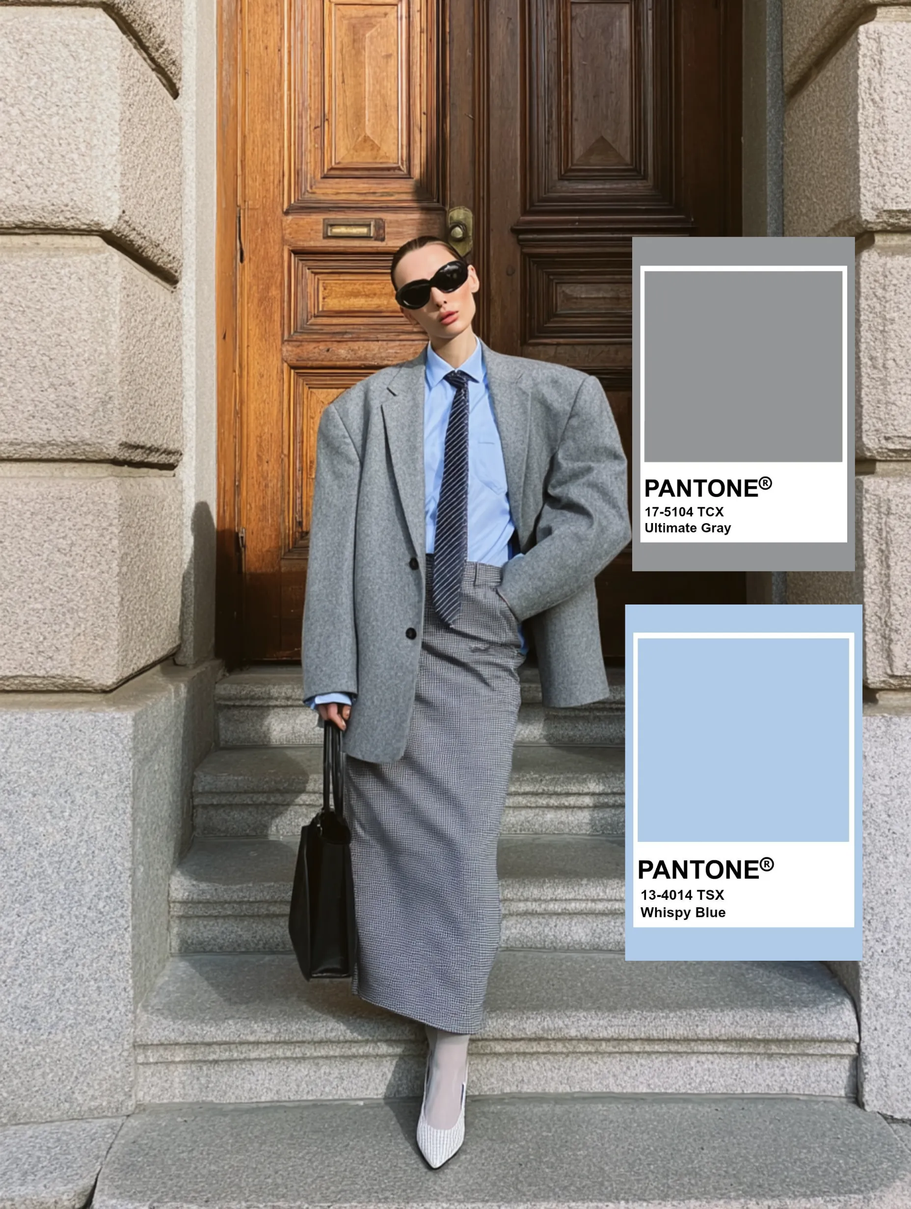 Bir binanın taş basamaklarında duran, büyük beden gri blazer ceket, açık mavi gömlek ve çizgili kravat giymiş şık bir kadının üzerinde Pantone Ultimate Gray ve Whispy Blue renk örneklerinin vurgulandığı, soğuk renklerle oluşturulmuş uyumlu bir kombin.