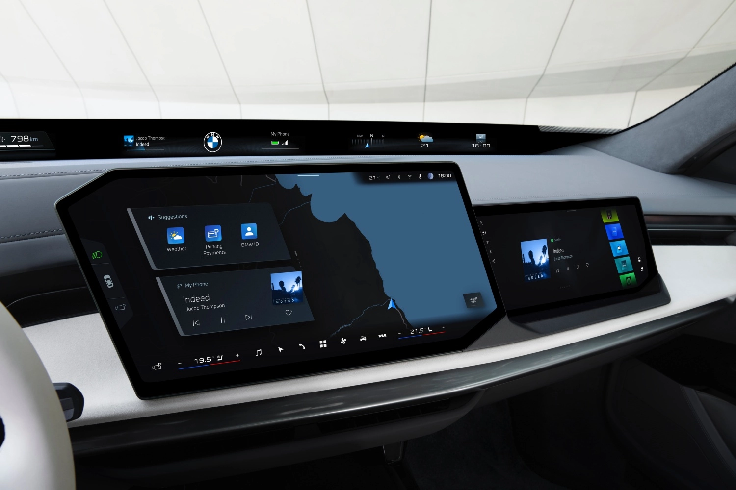 Yeni BMW 7 Serisi'nin lüks iç mekanında, sürücüyü ve ön yolcuyu saran kavisli geniş dijital gösterge paneli ile üstte ince bir şerit ekran dikkat çekerken, merkezdeki ekranda navigasyon haritası, hava durumu, park ödemeleri ve BMW ID gibi uygulamaların yanı sıra Jacob Thompson'ın Indeed şarkısı da gösterilen BMW yolcu ekranı öne çıkmaktadır.