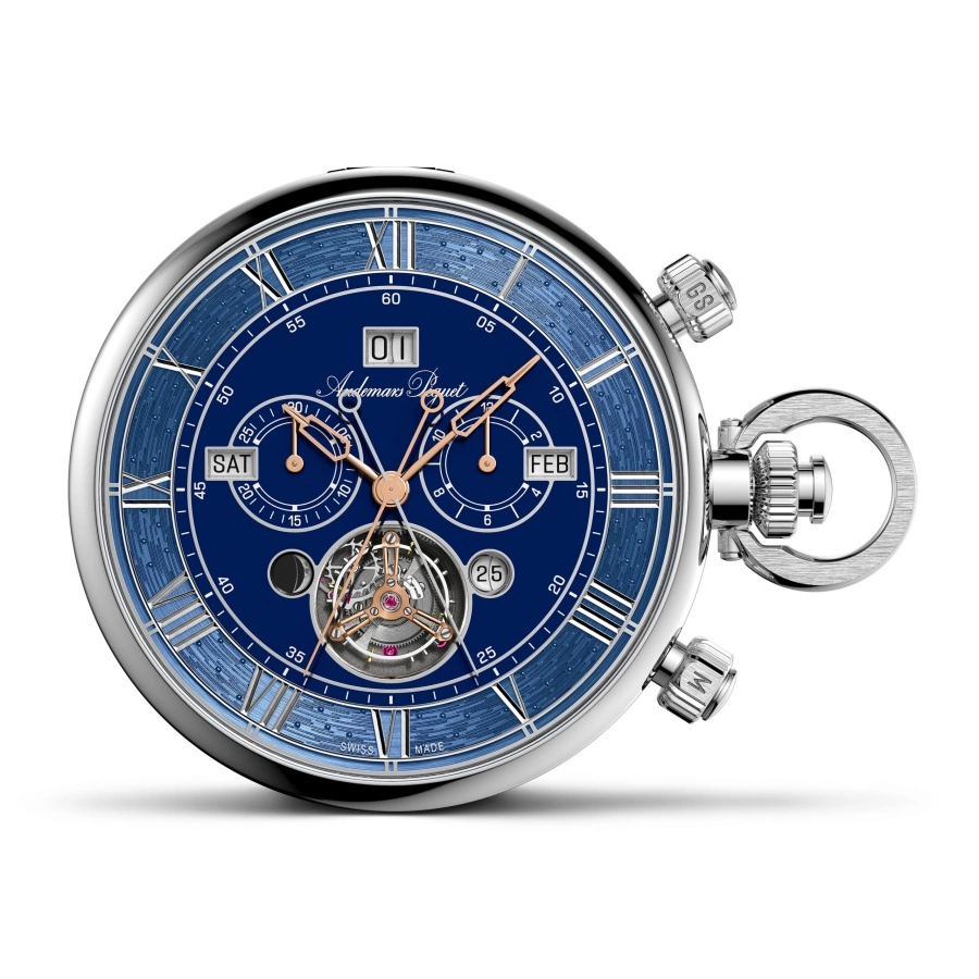 Koyu mavi, karmaşık dokulu kadranı, Romen rakamları, tarih, gün, ay göstergeleri ve görünen tourbillon mekanizması ile gümüş renkli kasaya sahip bu zarif Audemars Piguet Heritage cep saati, sağ tarafında kurma kolu ve buton detaylarını sergiliyor.