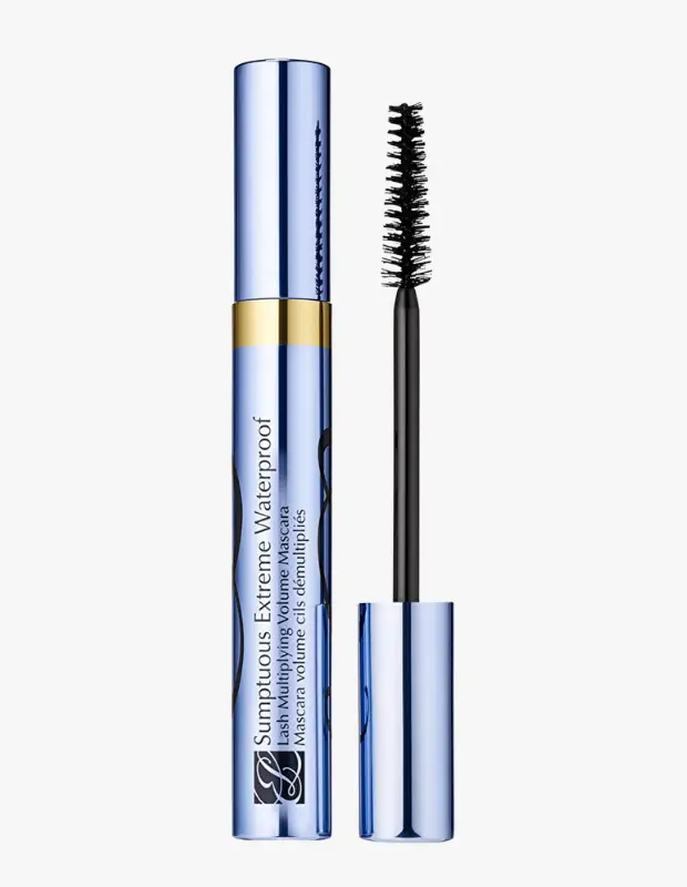 Estee Lauder Sumptuous Extreme Waterproof Maskara, parlak metalik mavi ve ortasında altın bant detayı olan şık tüpüyle, hacim veren simsiyah fırçası yanında gösterilerek beyaz zeminde dikkat çekici bir şekilde sergileniyor.