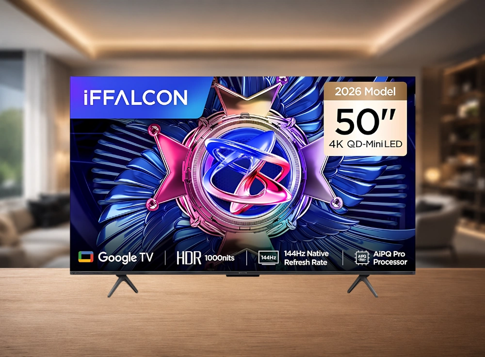 Modern bir oturma odası zemininde ahşap bir masa üzerinde duran, ekranında iFFALCON logosu, 2026 Model, 50 inç, 4K QD-Mini LED, Google TV, HDR 1000nits, 144Hz Native Refresh Rate ve AiPQ Pro Processor özelliklerini ve parlak renkli soyut bir madalya tasarımını gösteren siyah çerçeveli bir akıllı televizyon.