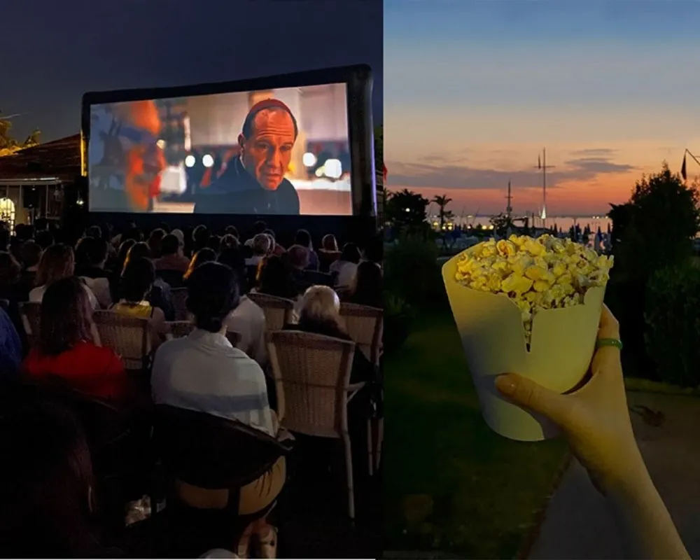 Sol tarafta İstanbul Yelken Kulübü'nde bir açık hava sineması etkinliğinde geceleyin büyük bir ekranda film izleyen seyirciler varken, sağ tarafta ise gün batımının kızıl renkleriyle aydınlanmış denize karşı, yelkenlilerin de silüetiyle, bir kişinin elinde tuttuğu bol patlamış mısır kovası yer alıyor.