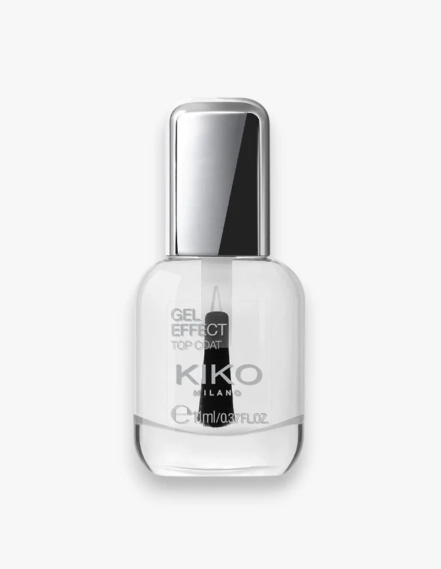 Şeffaf cam şişesinde, parlak gümüş renkli kapağı ve içinde siyah fırçasıyla öne çıkan, Kiko Milano markasına ait Gel Effect Top Coat yazılı oje, tırnaklara jel etkisi ve parlaklık vaat eden yeni formülüyle beyaz bir zeminde sergileniyor.