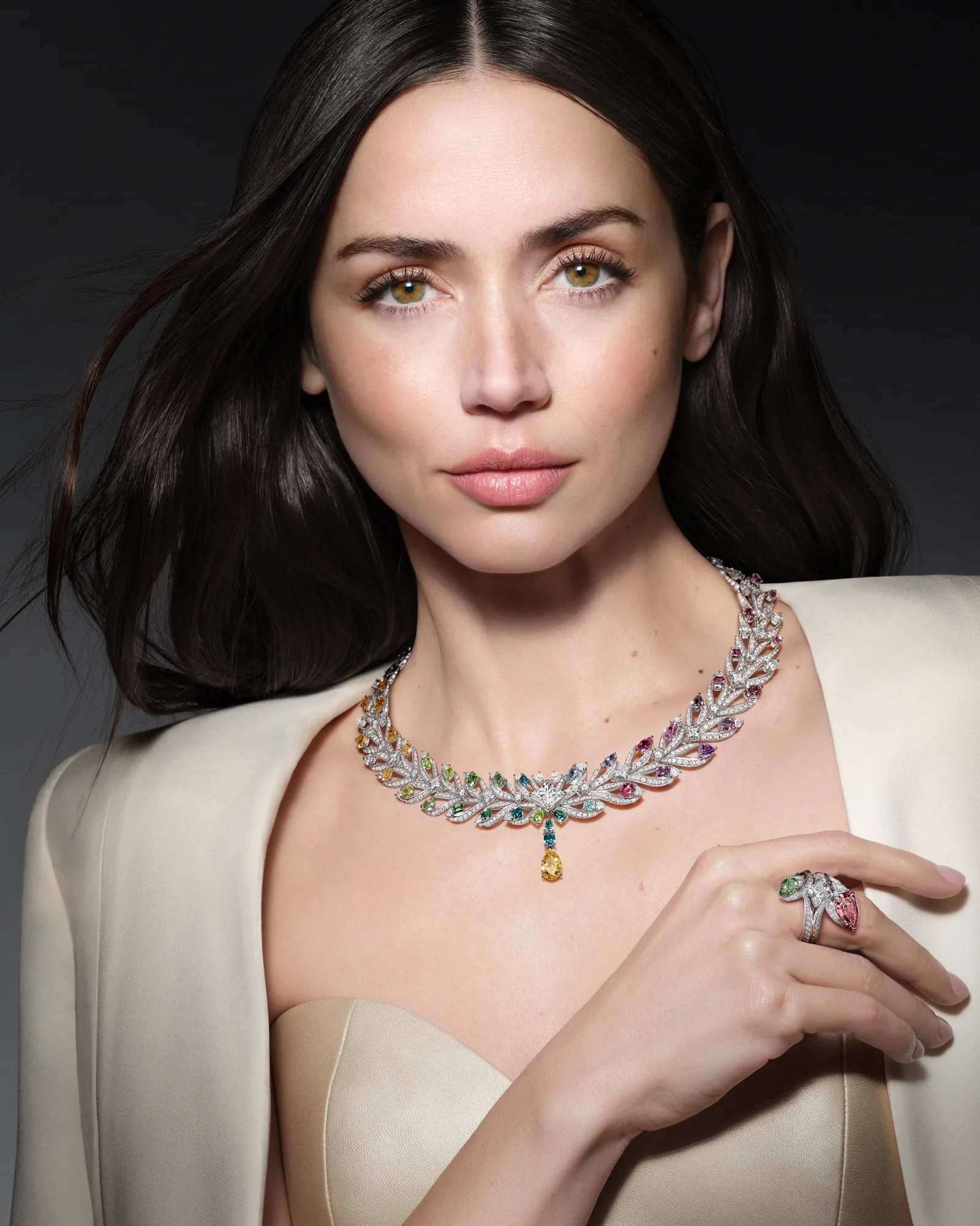 Louis Vuitton marka elçisi Ana de Armas, zarif duruşuyla Mythica koleksiyonunun defne tacı ilhamlı Victory kolyesini ve uyumlu yüzüğünü sergiliyor, renkli elmasların ışıkla zafer temasını yansıttığı bu yüksek mücevher tasarımları büyüleyici görünüyor.