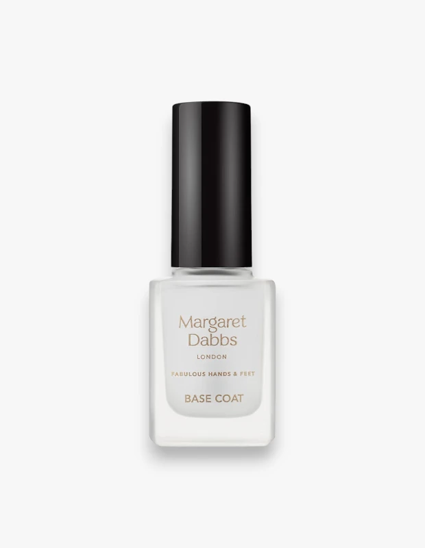 Margaret Dabbs London markasına ait, üzerinde altın rengi yazılarla markası ve BASE COAT ibaresi yer alan, şeffaf kare cam şişesi ve siyah silindirik kapağı bulunan, tırnaklar için besleyici baz kat ürününün düz beyaz bir arka plan üzerinde çekilmiş yüksek çözünürlüklü fotoğrafı.