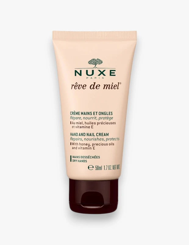 Nuxe Rêve de Miel El ve Tırnak Kremi'nin bal, değerli yağlar ve E vitamini içeren onarıcı, besleyici ve koruyucu özelliklerini vurgulayan şeftali renkli 50 ml'lik tüpü beyaz bir zeminde dikey olarak sergileniyor.