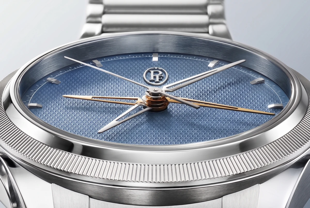 Mavi giyoş desenli kadranı, parlak gümüş renkli kasası, yivli bezeli ve merkezi altın tonlu kronograf ibreleriyle dikkat çeken Parmigiani Fleurier Tonda PF Chronographe Mysterieux lüks kronograf saati yakından gösteriliyor.
