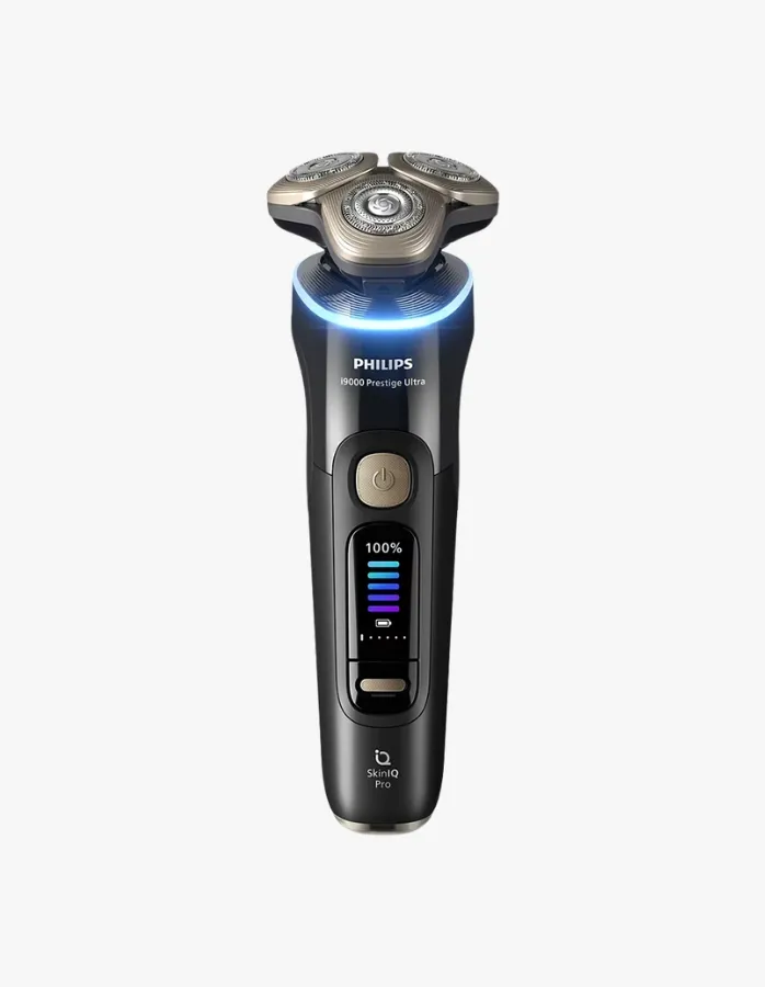 Beyaz bir arka plan üzerinde, şarjı yüzde yüz dolu ve mavi ışıkla aydınlatılmış döner başlıkları olan siyah renkli Philips S9000 Prestige Ultra erkek tıraş makinesi, modern erkek bakımı için ideal bir seçim olarak görünüyor.