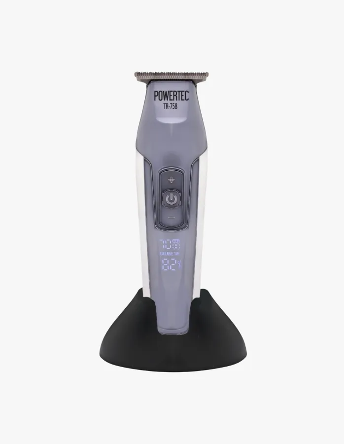 Bir Powertec TR-758 model erkek bakım tıraş makinesi, beyaz ve açık gri renklerde, metalik bıçaklı ve pil yüzdesini gösteren dijital ekranıyla şarj standında dik duruyor, erkek bakımı için modern bir çözüm sunuyor.