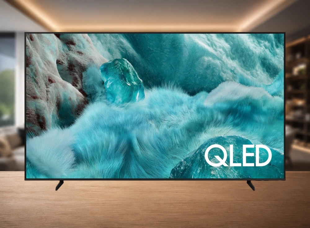 Ahşap bir yüzeyde modern bir yaşam alanında konumlanmış, ekranında buzlu turkuaz renklerde bir manzara ve büyük beyaz QLED logosu beliren bu 85 inç Samsung 4K sinema televizyonu, etkileyici görüntü kalitesini sergiliyor.