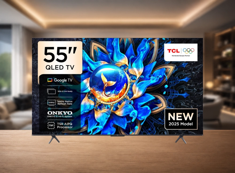 Bu TCL 55 inç QLED akıllı TV, şık ve ince tasarımıyla ahşap bir yüzey üzerinde duruyor; ekranında mavi ve altın renklerinde göz alıcı soyut bir çiçek sanat eseri sergilenirken, Google TV ve 144Hz yerel yenileme hızı gibi yeni 2025 model özellikleri belirgin şekilde belirtilmiş.